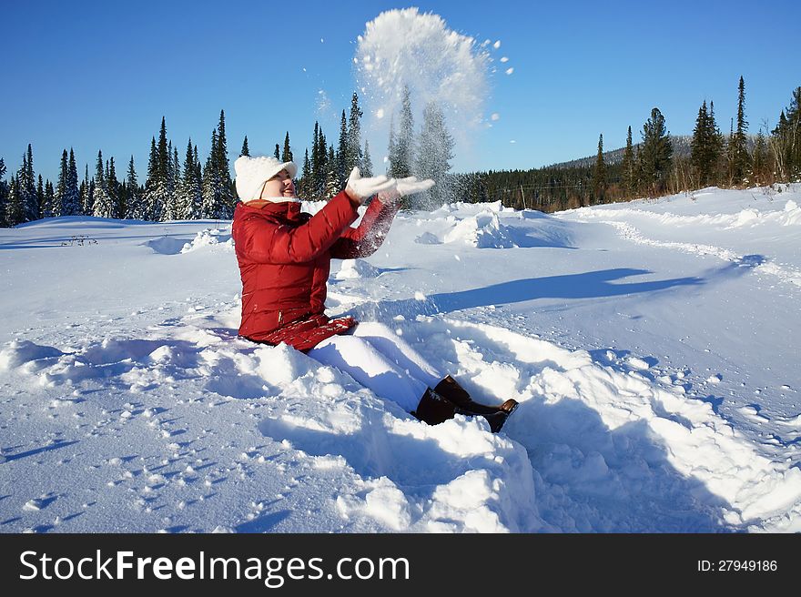 Girl sitting at snow on a winter day.