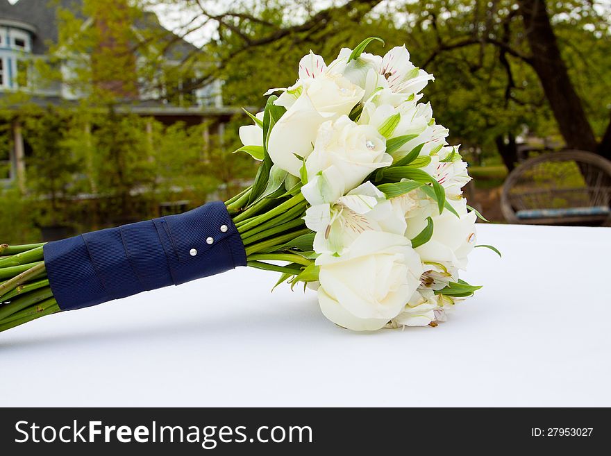 A white flower bouquet at a wedding ceremony with jewels in the flowers. A white flower bouquet at a wedding ceremony with jewels in the flowers.