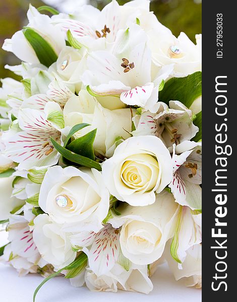 A white flower bouquet at a wedding ceremony with jewels in the flowers. A white flower bouquet at a wedding ceremony with jewels in the flowers.