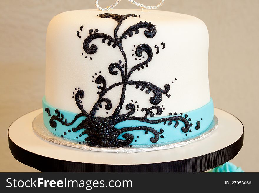 A modern wedding cake with white blue and black and a creative frosting design at a wedding ceremony and reception.