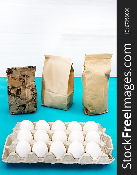 Egg set with three paper packs, on white and blue background