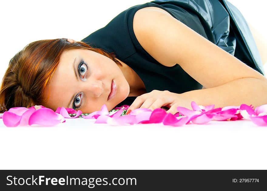 Beautiful girl in rose petals isolated on white background
