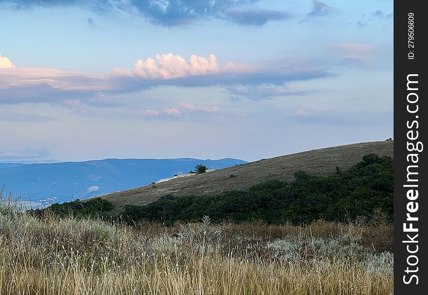 Steppe Hills. Evening Sky. A Mountain On The Horizon. Summer Sunset.