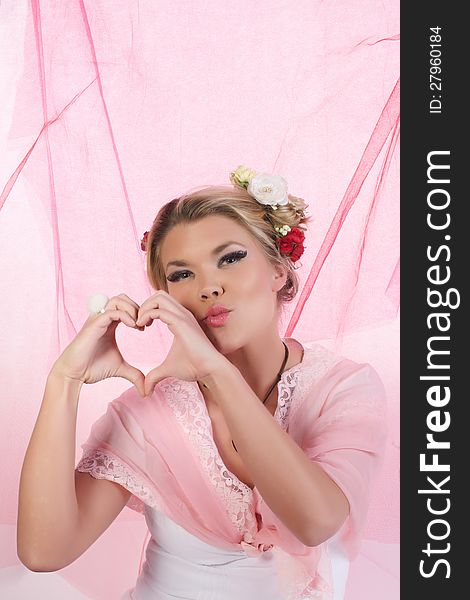 Cute, beautiful, sexy valentine girl making a heart symbol with her hands