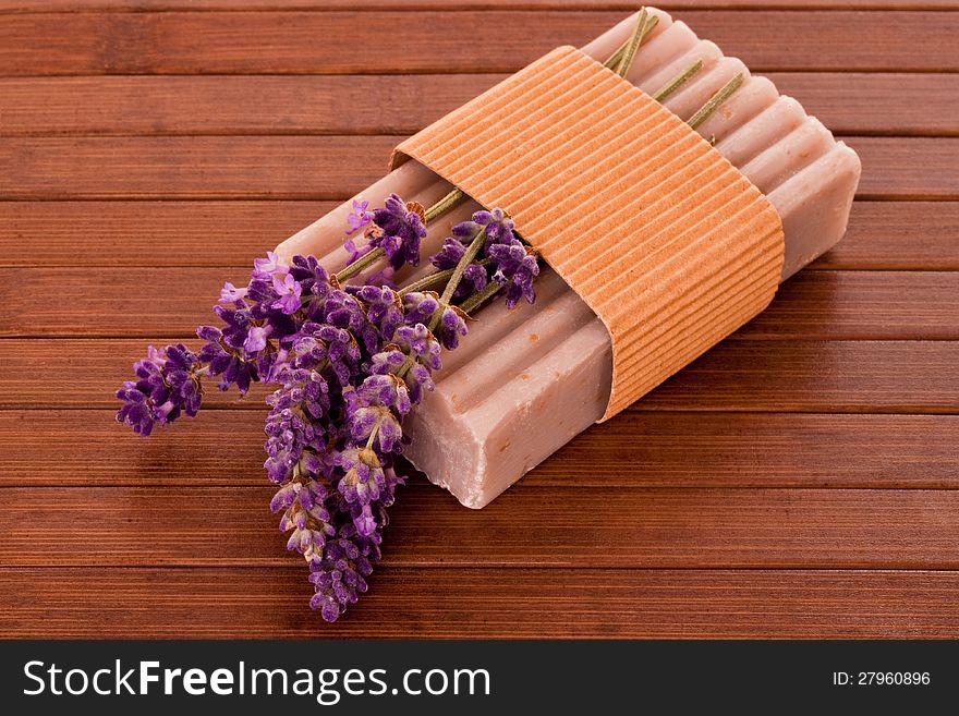 Bar of soap with lavender blossoms over violet background. Bar of soap with lavender blossoms over violet background