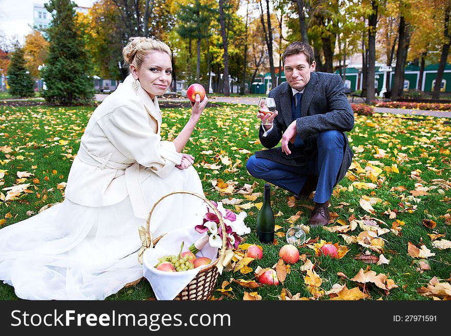 Groom keeps glass of brandy, and bride with apple