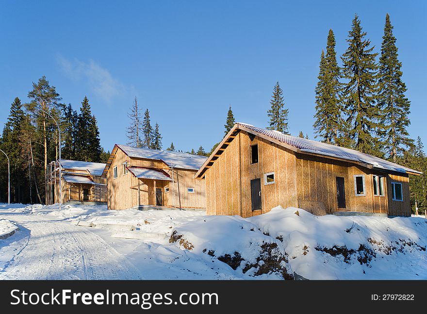 Recently constructed three country houses in wood in a sunny day against the blue sky