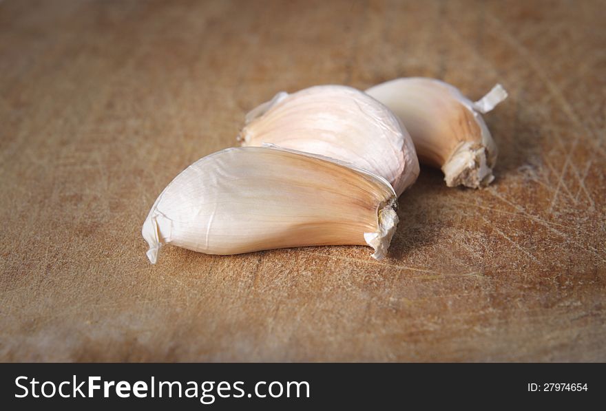 Three white onion / garlic on wooden board