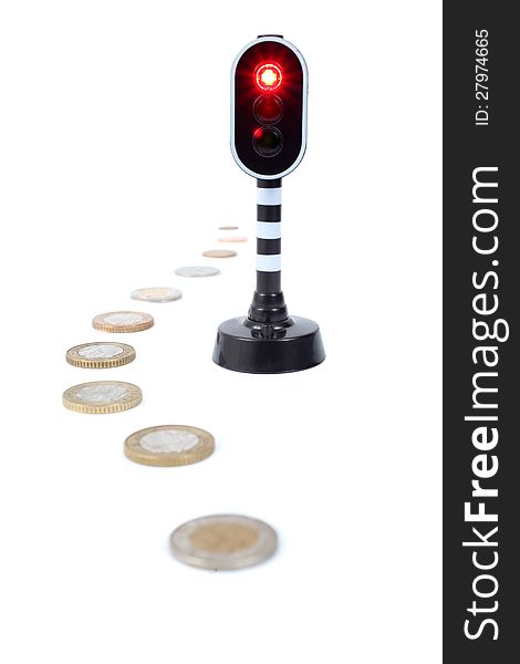 Coins next to a traffic light that has turned red.  Isolated on a white background. Coins next to a traffic light that has turned red.  Isolated on a white background