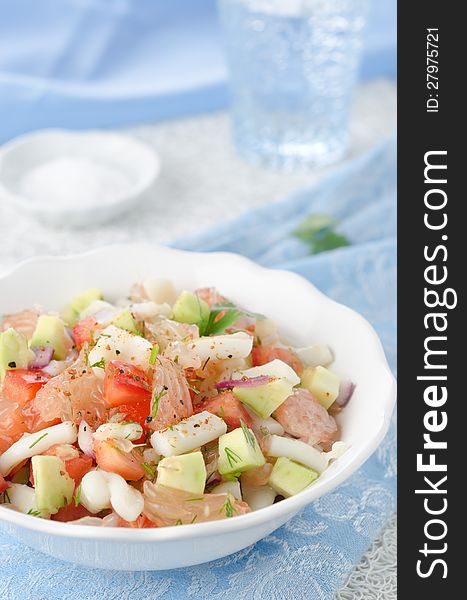 A bowl of salad with squid, avocado and grapefruit