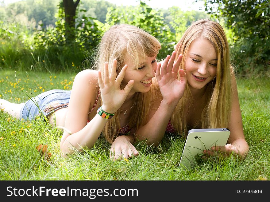 Girls waving with a tablet