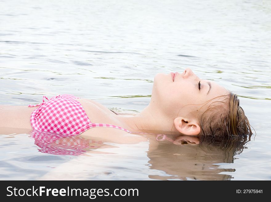 1 girl is floating in the water. 1 girl is floating in the water