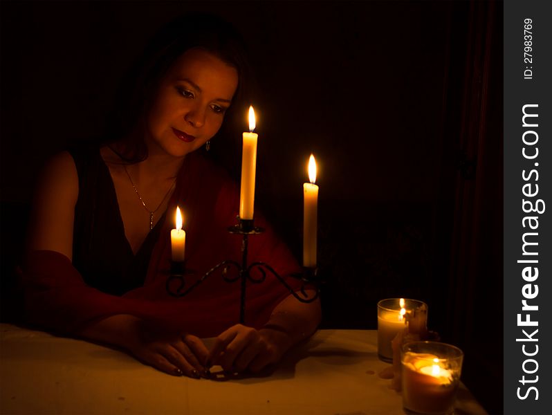 The beautiful young girl with candles on the black background. The beautiful young girl with candles on the black background