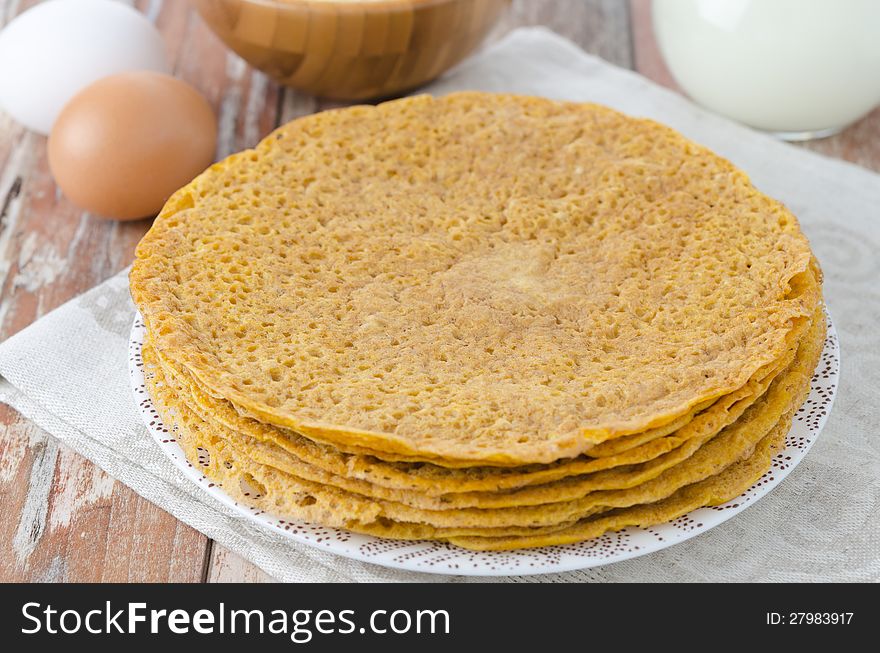Stack of crepes made â€‹â€‹of corn flour on a plate and baking ingredients