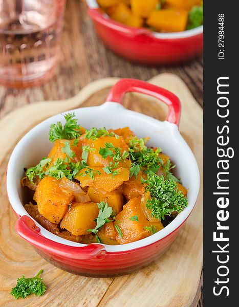 Pumpkin baked in a tomato sauce with garlic and herbs closeup