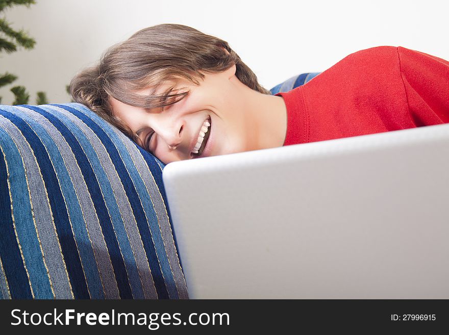 Teenage boy using laptop and laughing