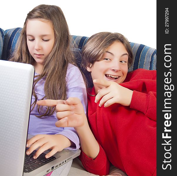 Brother and sister using laptop on the sofa