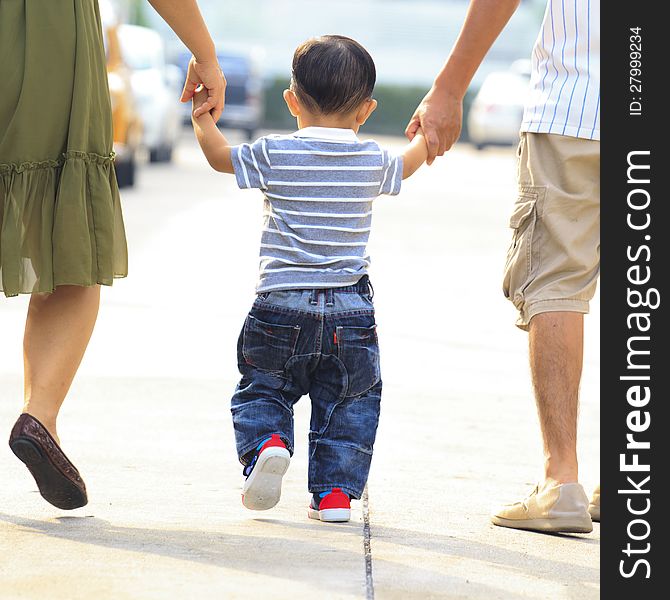 Parents holding hand of his son in outdoors