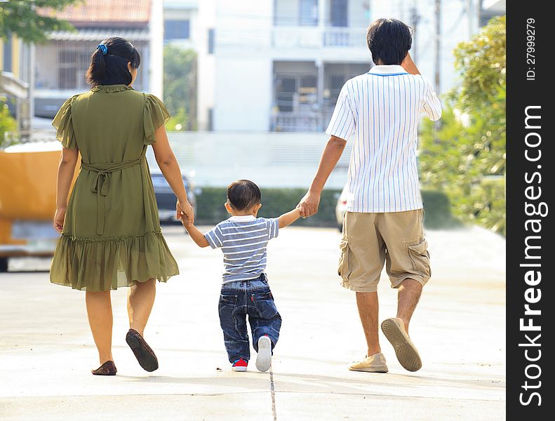 Parents holding hand of his son in outdoors