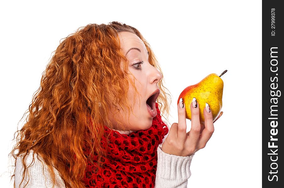 Redheaded girl wants to eat a pear isolated on white