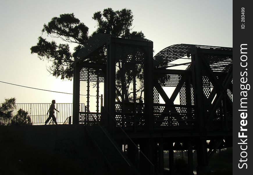 Silouette of a bridge with a person walking