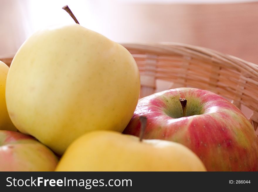 Red and yellow apples in a basket.