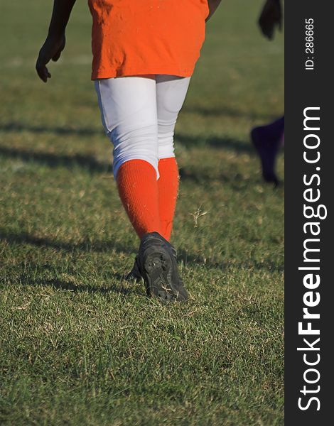 Child going ready to play football, bright orange uniform. Child going ready to play football, bright orange uniform