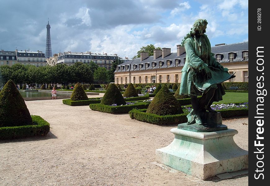 A view of a park with a statue and the Eiffel Tower in the background. A view of a park with a statue and the Eiffel Tower in the background