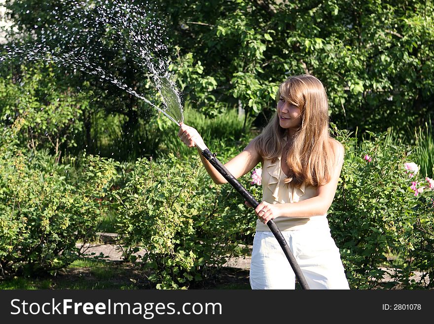 Beautiful girl in the garden with hose. Beautiful girl in the garden with hose