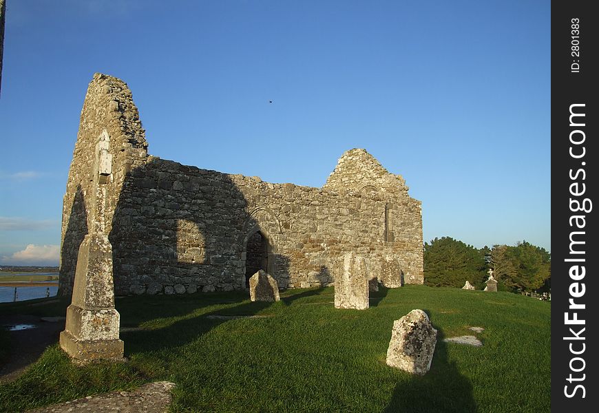 Ruins of church dating to 12th century Ireland with old cemetry in forground and river in background. Ruins of church dating to 12th century Ireland with old cemetry in forground and river in background