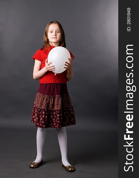 The girl with a ball in studio on a grey background. The girl with a ball in studio on a grey background