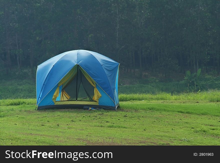 Small, blue tent on a meadow