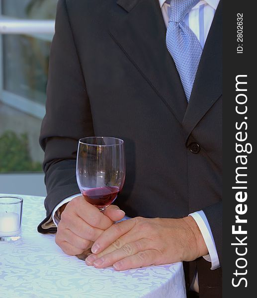 Man with wine glass standing at a table