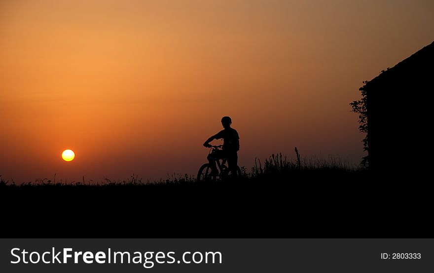 Mountain biker silhouette in sunrise