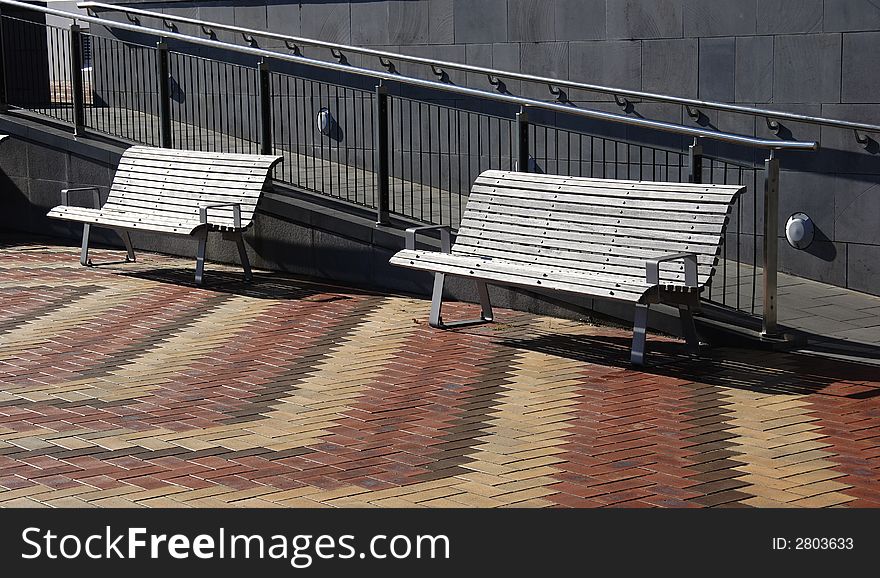 Two park benches on brick floor