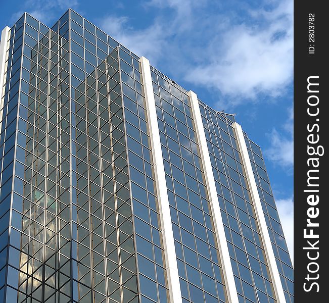 Clouds reflecting in the windows of a golden skyscraper. Clouds reflecting in the windows of a golden skyscraper.