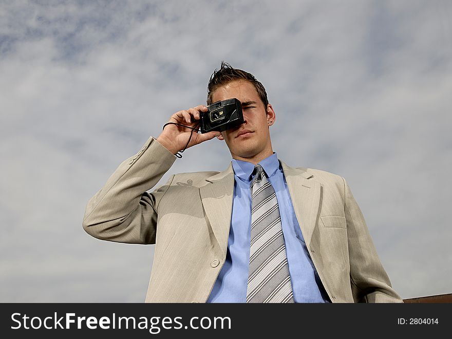 Young businessman with camera in his hands taking picture