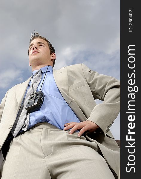 Young businessman with camera climbing on his neck.