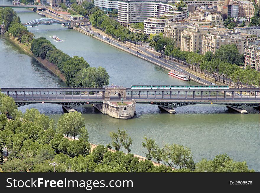 View from the Eiffel tower onto the Seine river in Paris. A train crossing the bridge over the river. View from the Eiffel tower onto the Seine river in Paris. A train crossing the bridge over the river