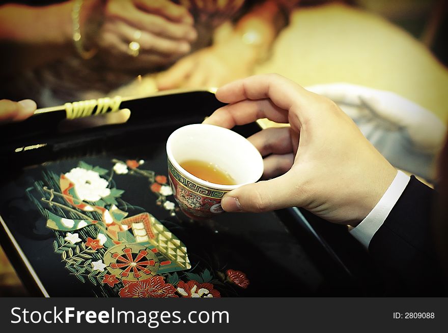 Serving tea to someone during a ceremony. Serving tea to someone during a ceremony