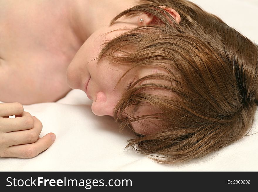 Beautiful naked young woman sleeping on white beddings, very real with messy hair, looks relaxed. Beautiful naked young woman sleeping on white beddings, very real with messy hair, looks relaxed