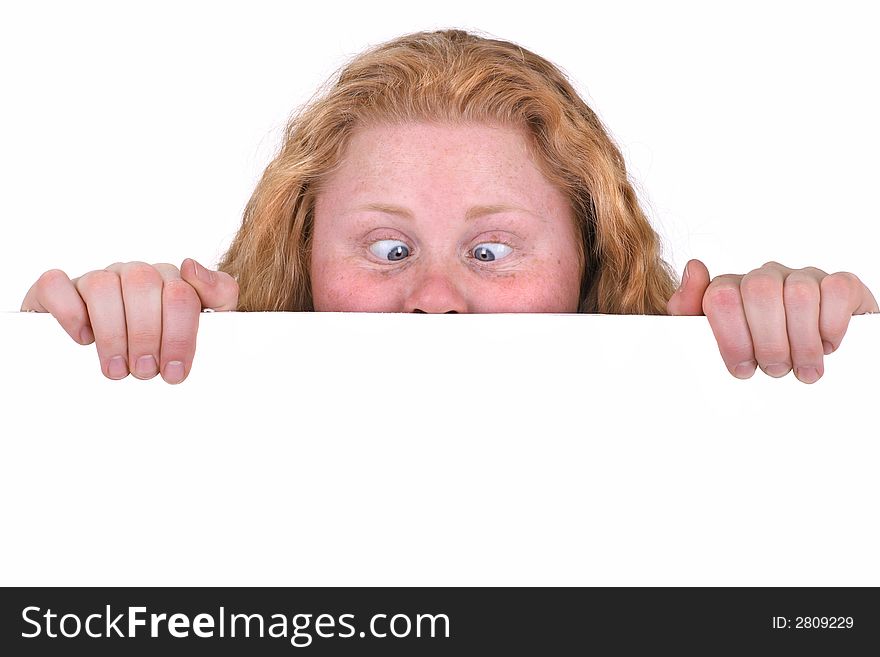 Cute curly girl looking at something very intensely with eyes crossing. Isolated behind a white board, with lots of copyspace. Cute curly girl looking at something very intensely with eyes crossing. Isolated behind a white board, with lots of copyspace