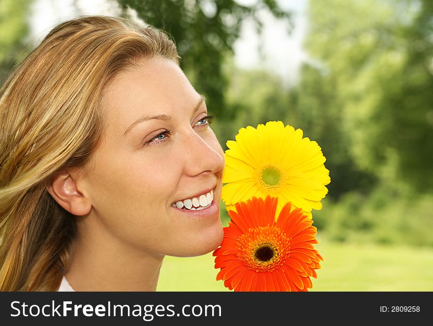Nature portrait of a smiling young woman with two daisies. Nature portrait of a smiling young woman with two daisies