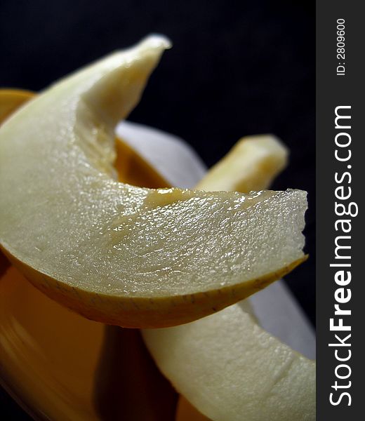 Two slices of sweet melon on a yellow plate