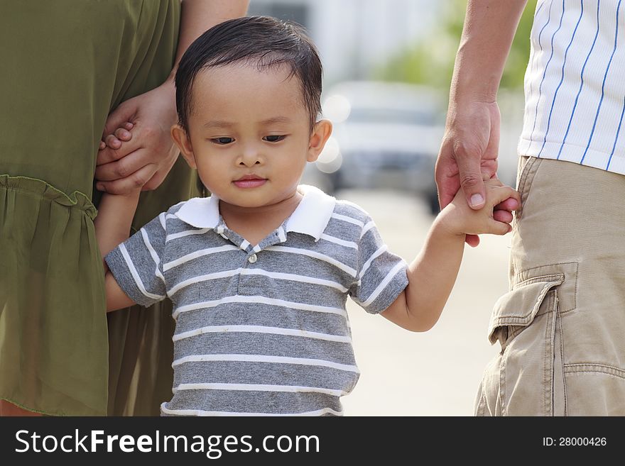 Parents holding hand of his son in outdoors