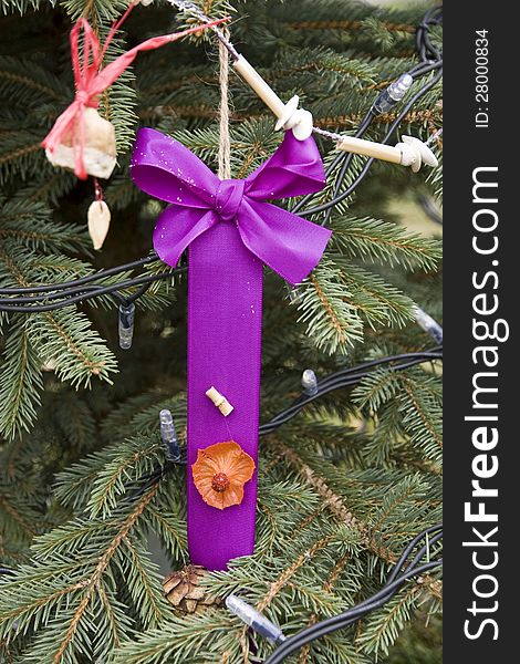 Christmas purple ribbon hanging on a spruce branch. Christmas purple ribbon hanging on a spruce branch