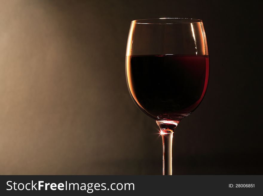Elegant goblet of red dry wine on dark background