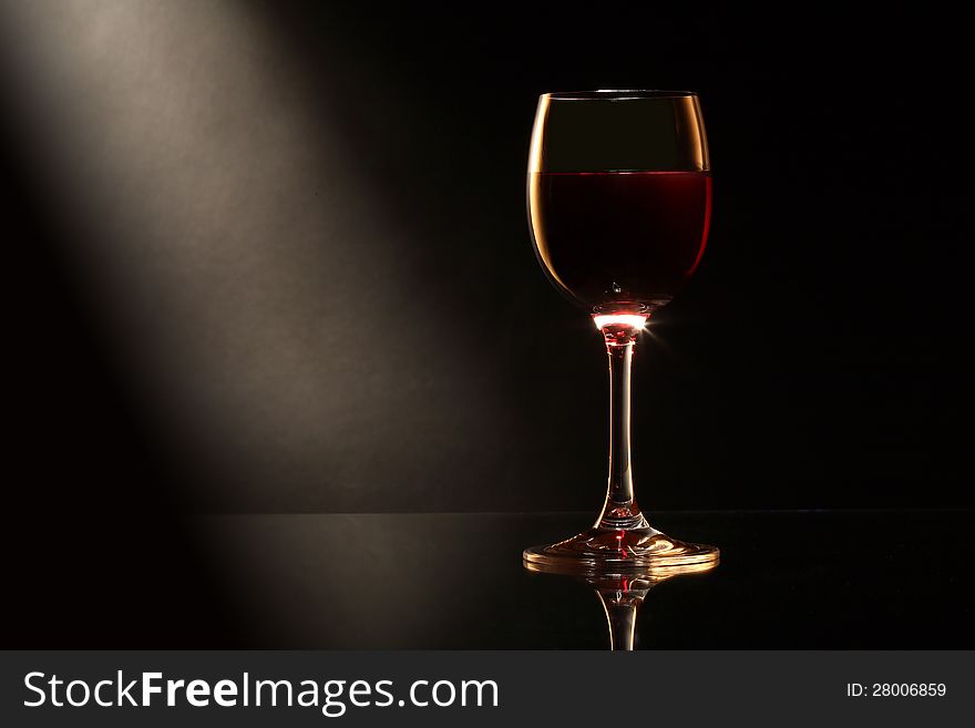 Elegant goblet of red dry wine on dark background