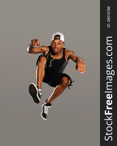 Hip Hop style dancer jumping isolated on a gray background