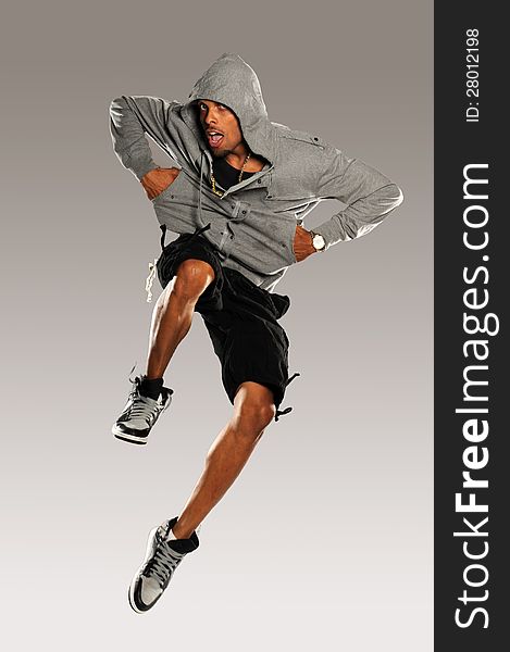 Hip Hop Dancer jumping wearing shorts and tennis shoes on a neutral background